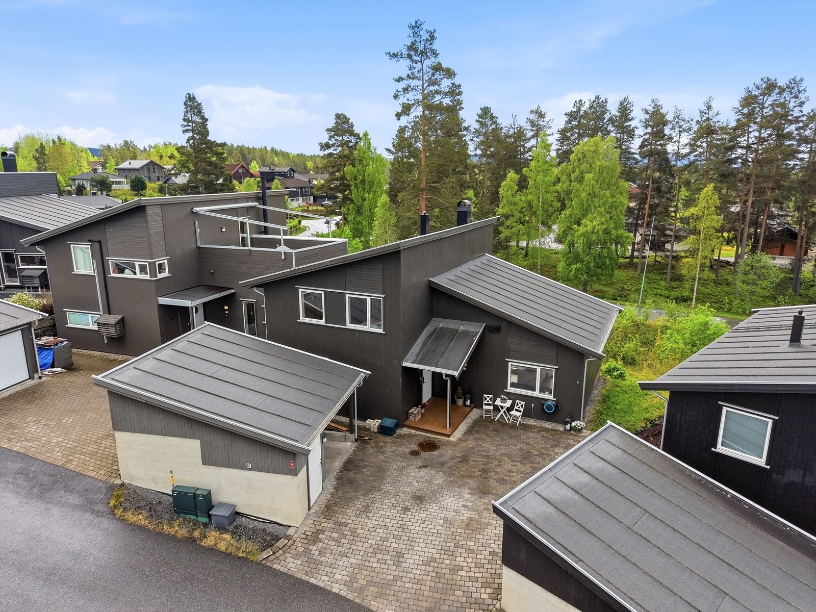 Eiendommen har en egen carport med tilhørende bod, og gårdsplassen er pent opparbeidet med belegningsstein. Galleribilde