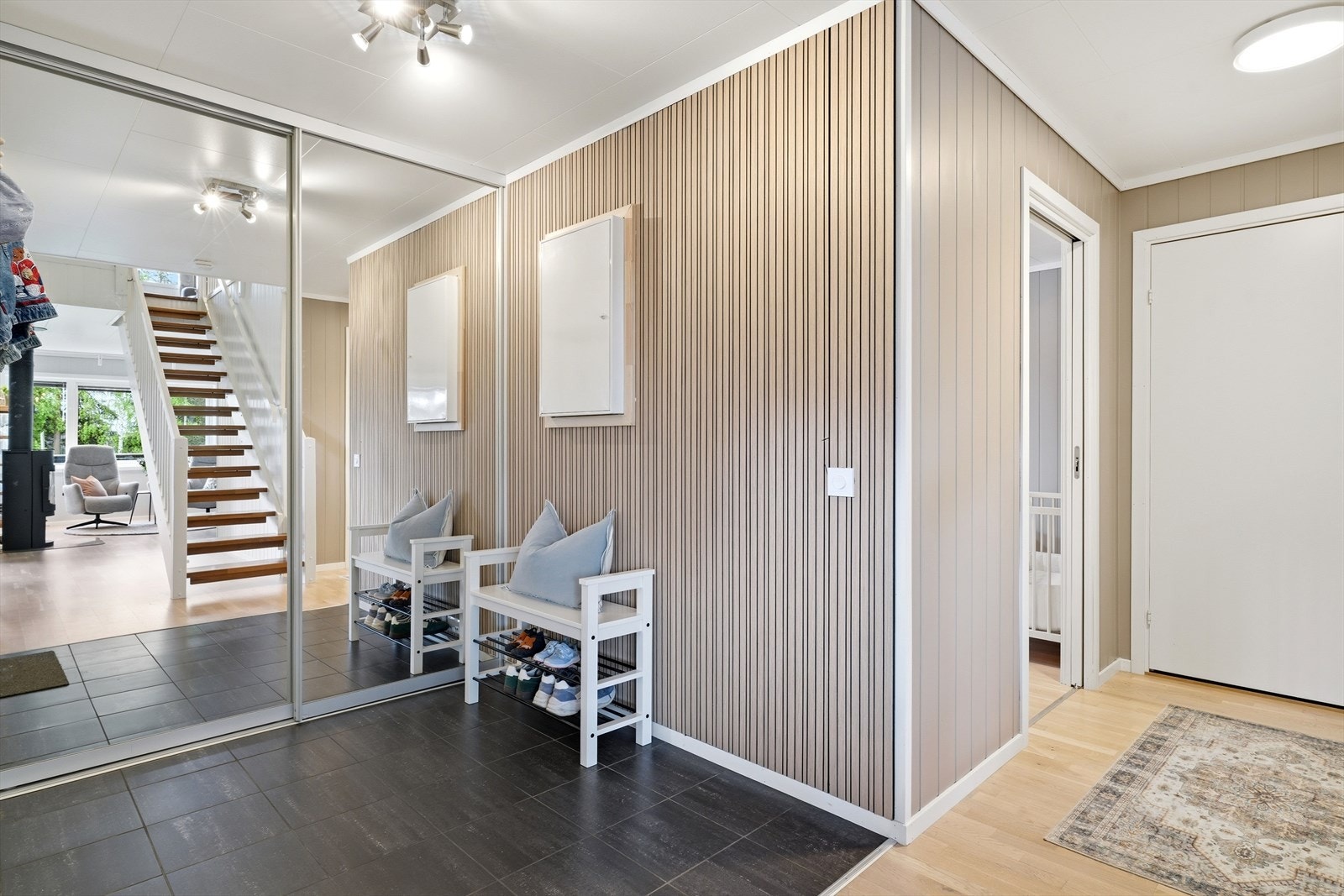 Entréen har flislagt gulv og god plass til oppbevaring av yttertøy i en stor skyvedørsgarderobe. Galleribilde
