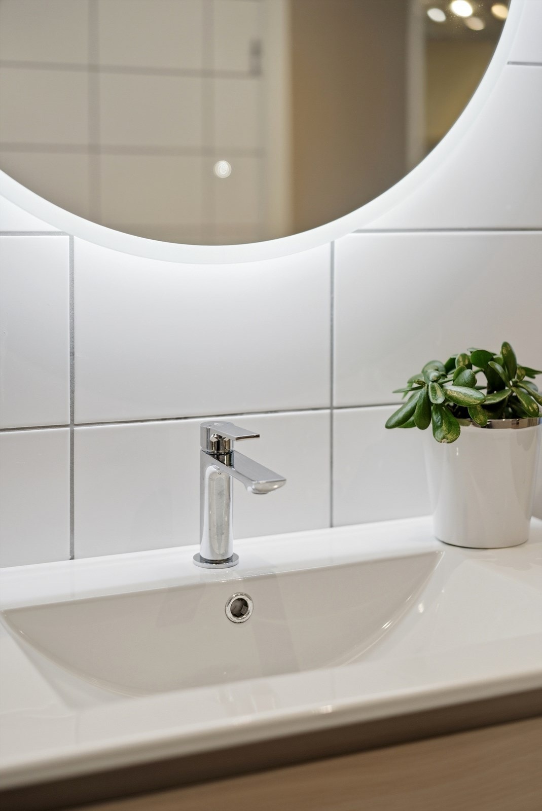 Moderne baderomsinnredning med servant og speil med integrert belysning. Galleribilde