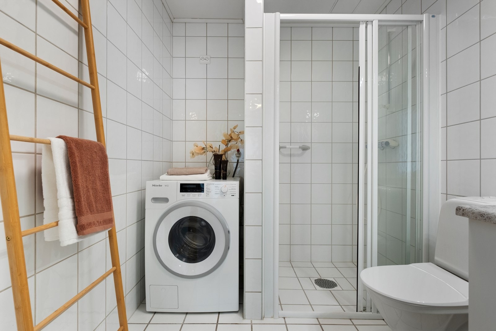 Badet har flislagte gulv og vegger, malte innvendige tak og gulvvarme. Det har dusjnisje, toalett, innredning med servant og opplegg for vaskemaskin. Det er naturlig ventilering. Galleribilde