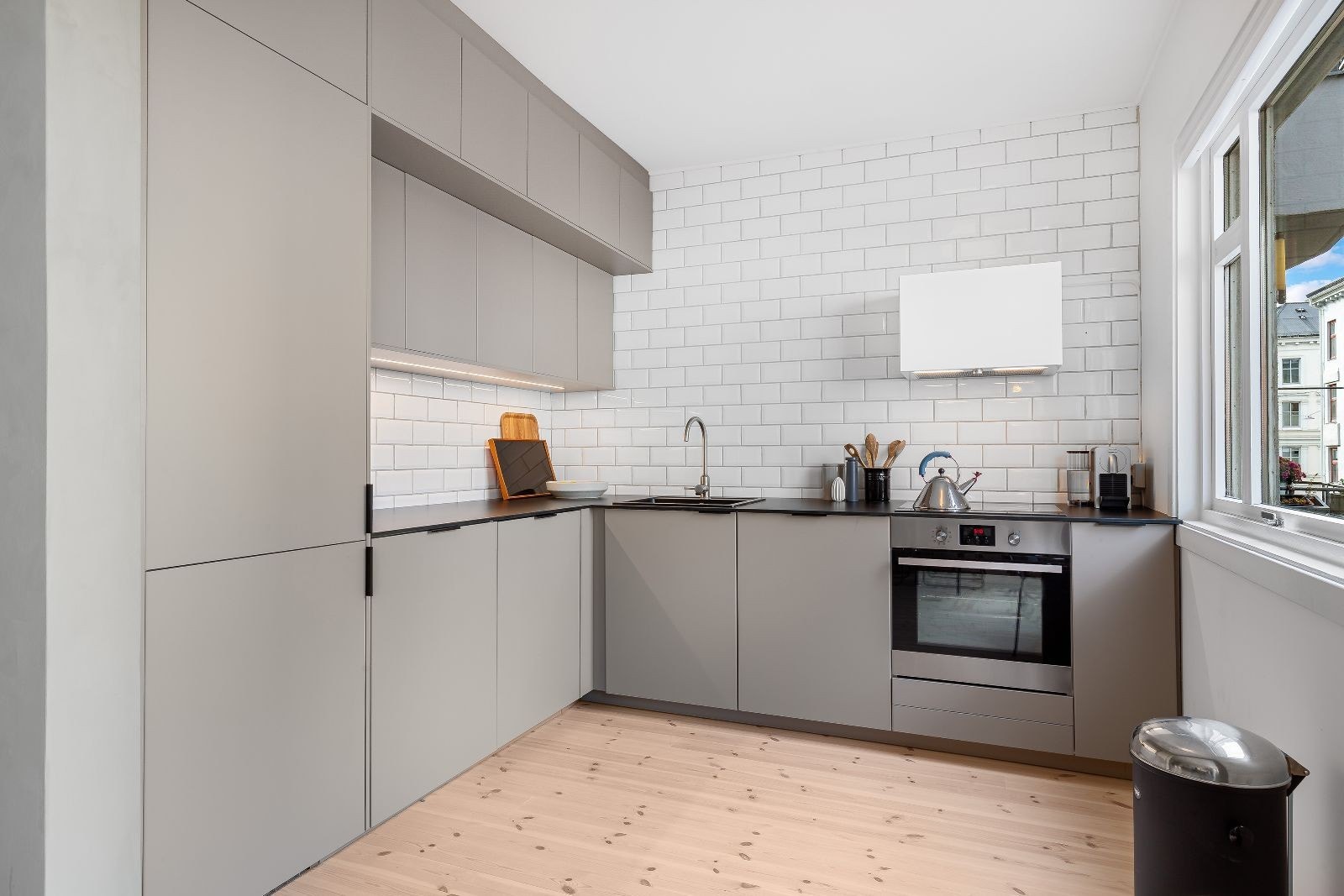 Takhøy kjøkkeninnredning fra 2019 med matte fronter og kompaktlaminat benkeplate. Galleribilde
