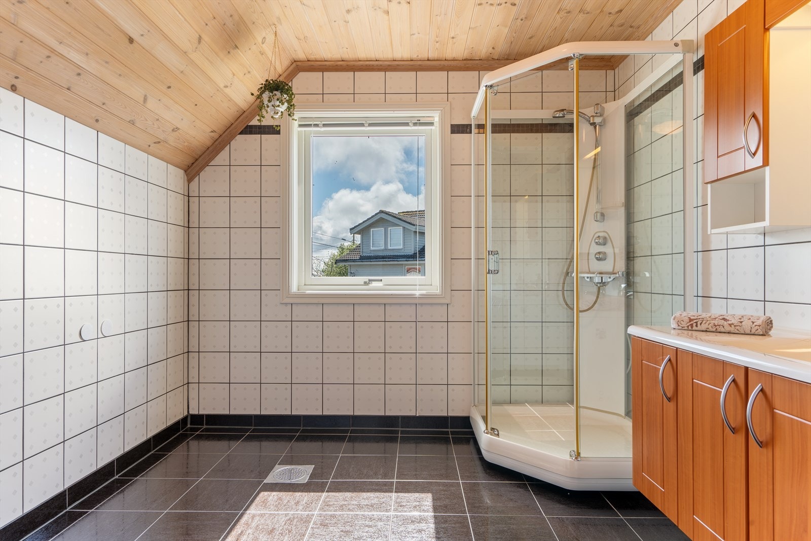 Badet har flislagt gulv med elektriske varmekabler og fliser på veggene. Galleribilde
