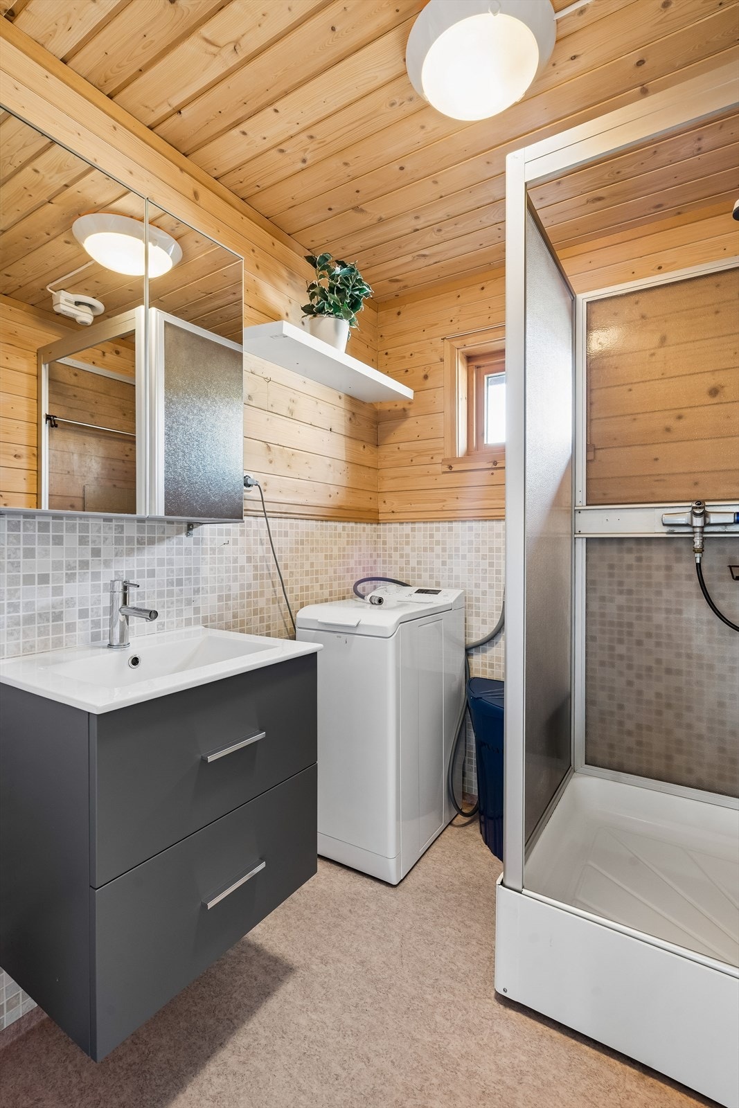 På badet er det i tillegg til vask og dusj, plass til en vaskemaskin. Her ligger alt til rette for lengre opphold med gode fasiliteter. Galleribilde