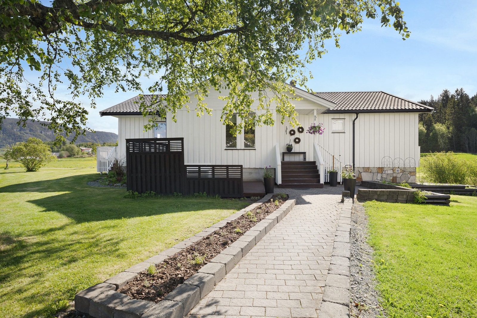 Pent opparbeidet adkomst til inngangspartiet med belegningsstein. Galleribilde