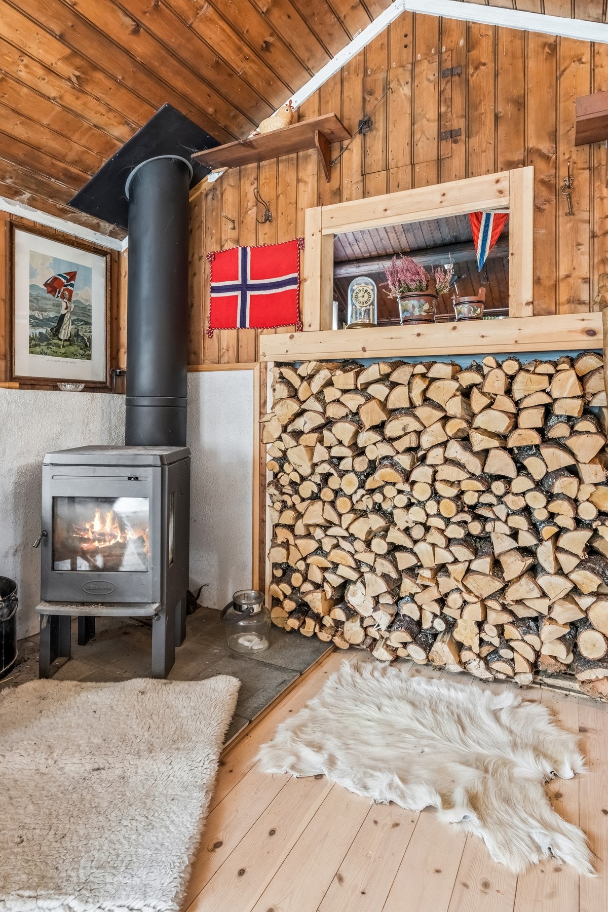 Vedovnen er en sentral og hyggelig varmekilde i rommet. Oppvarming skjer med vedfyring og strøm. Galleribilde