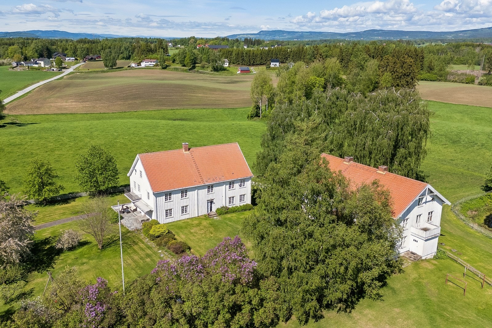 Landbrukseiendom i full drift med tre boenheter, moderne driftsbygninger og et historisk gårdstun som sentrum. Galleribilde