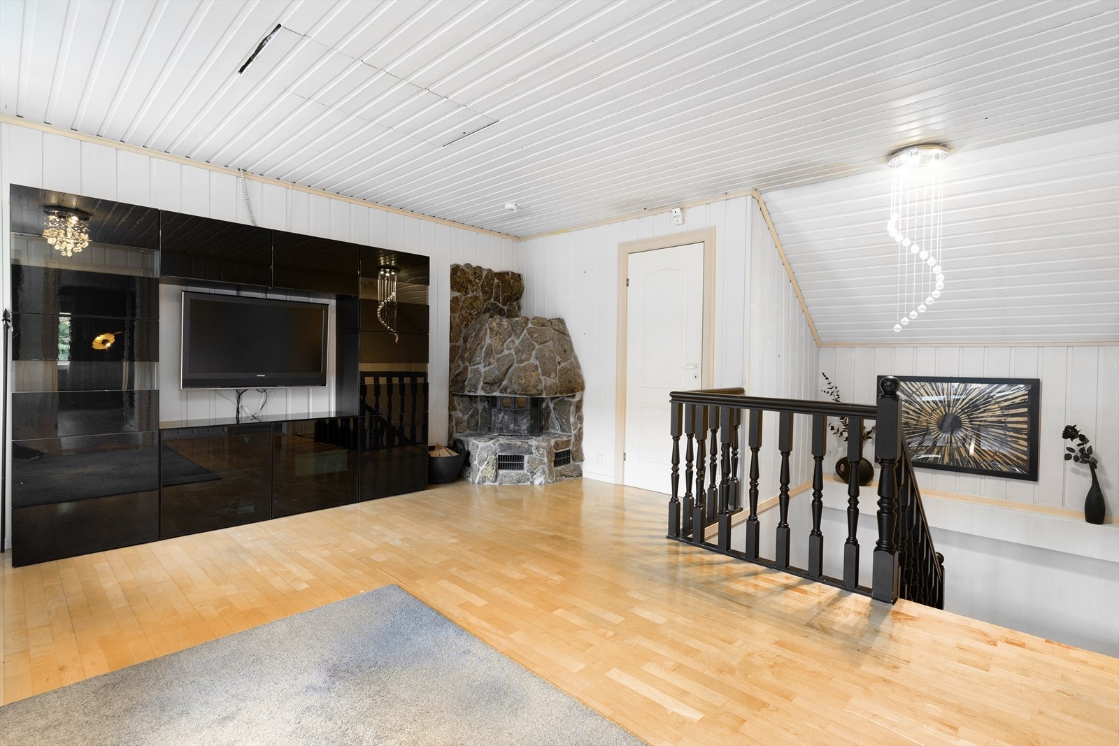 En murt natursteinspeis med innsats er et sentralt element i loftstuen. Galleribilde