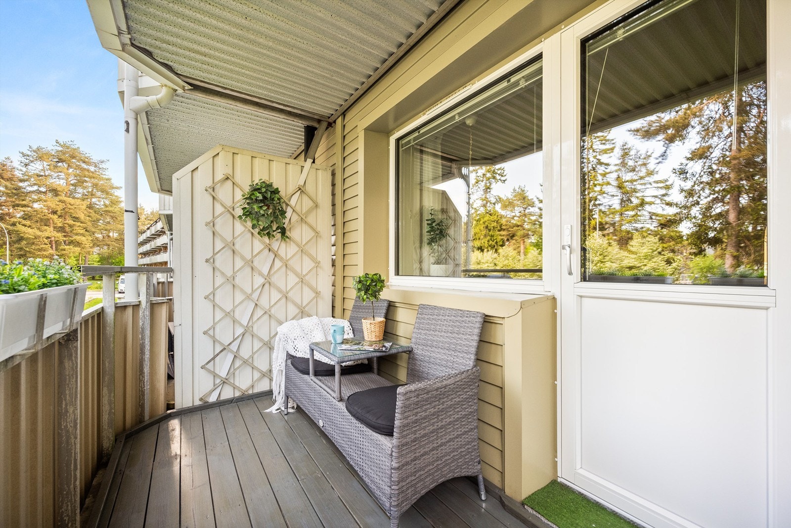 Balkongen har overbygg som gir lunere bruk gjennom store deler av året, og terrassebord på gulv gir et varmt og praktisk uttrykk. Galleribilde