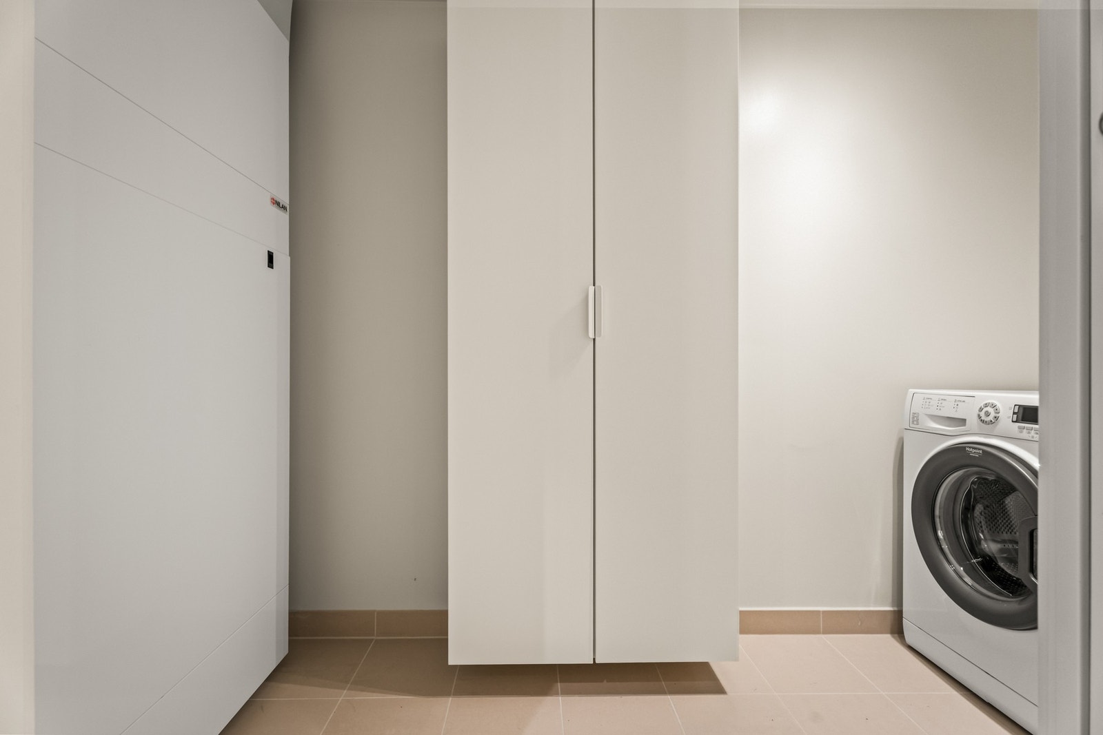 Tilliggende badet finner man et teknisk rom med garderobeskap, flislagt gulv og opplegg for vaskemaskin. Galleribilde