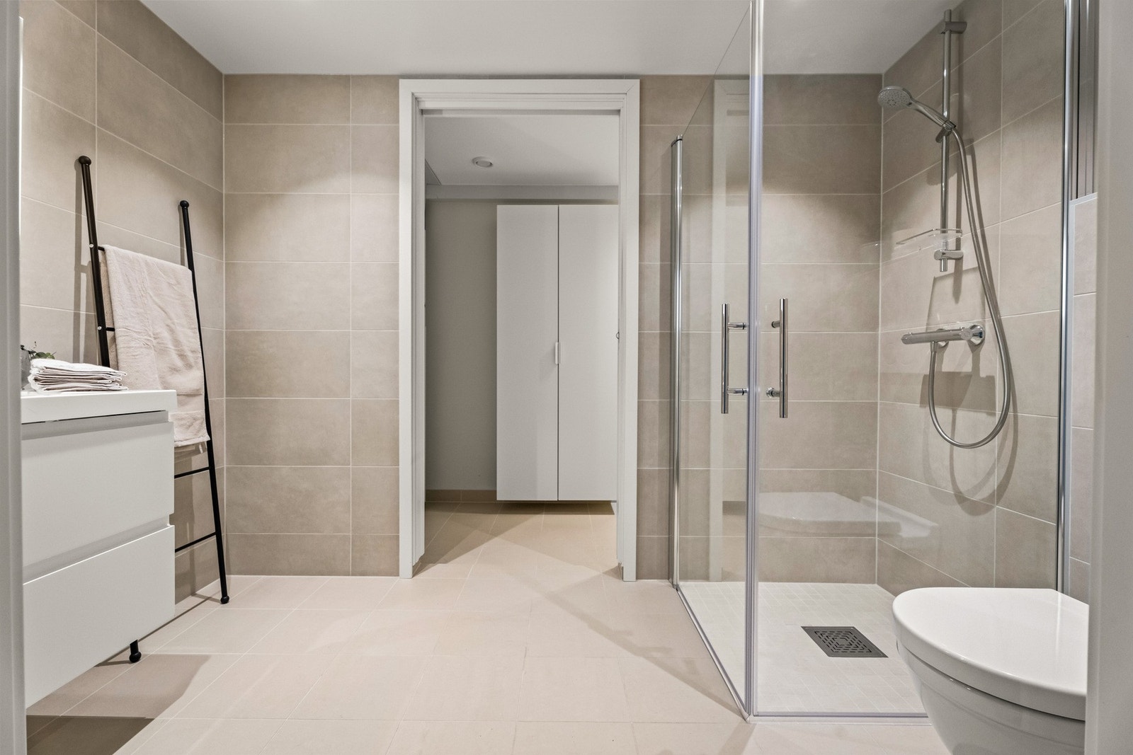 Dette badet har et dusjhjørne med mosaikkfliser og innfellbare glassdører. Galleribilde