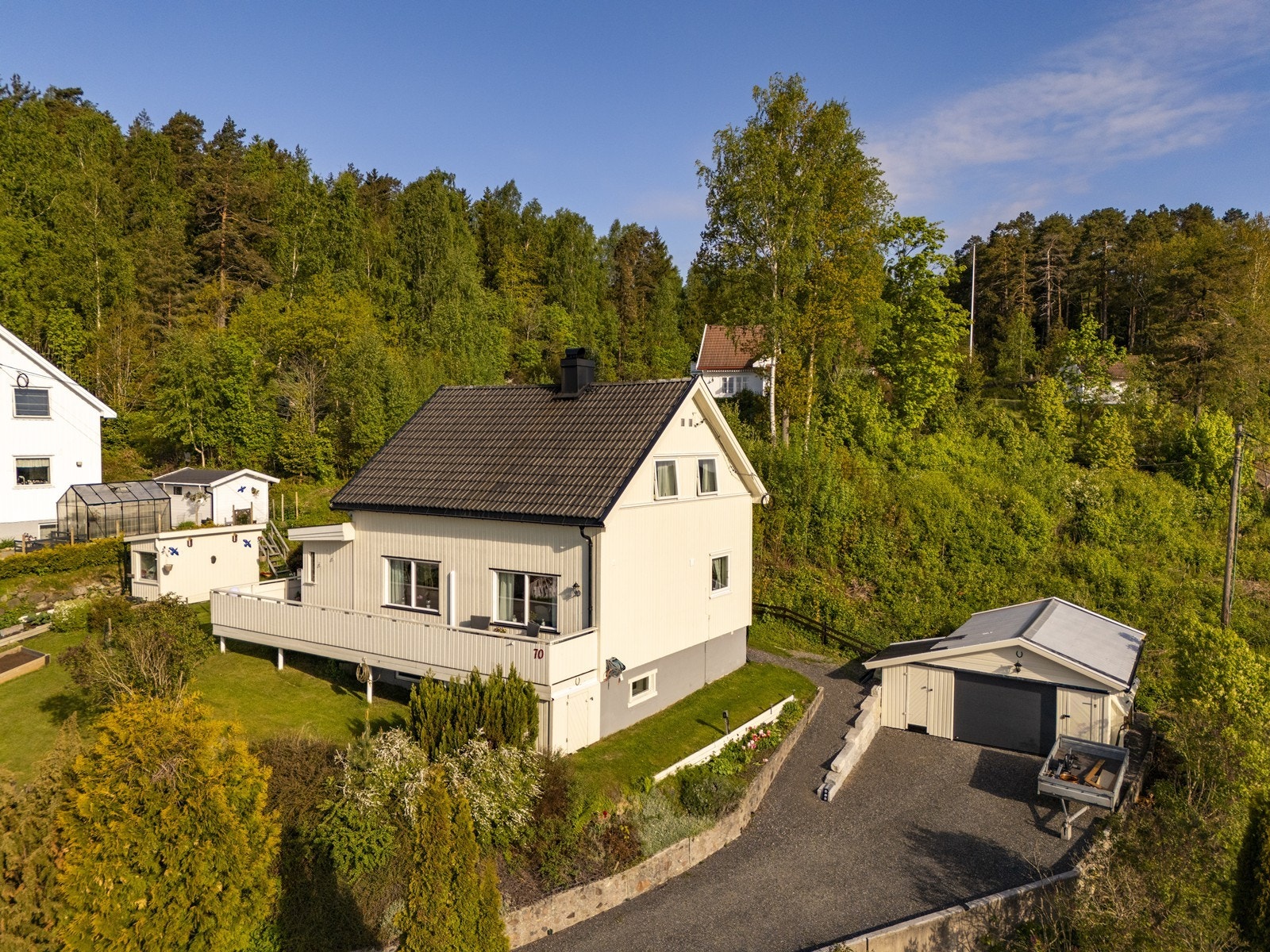 Eiendommen inkluderer en frittstående garasje og gruset innkjørsel. Galleribilde