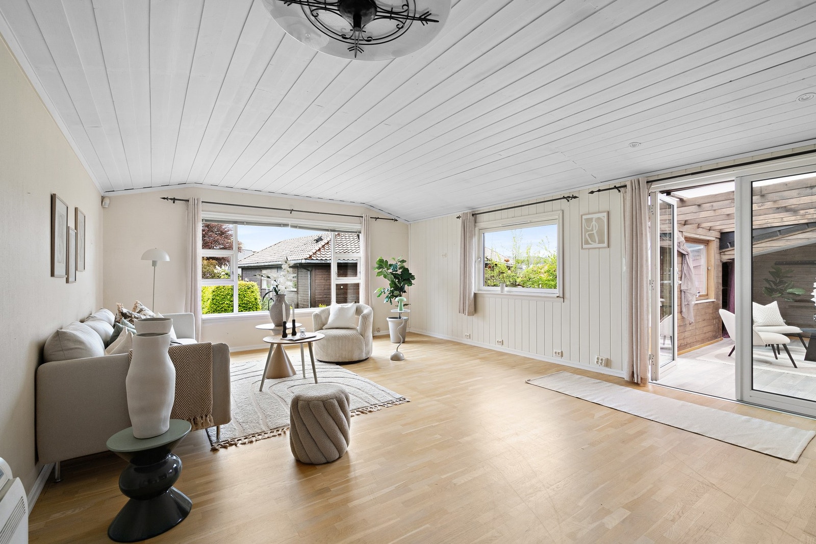 Stue med store vindusflater som slipper inn rikelig med dagslys Galleribilde