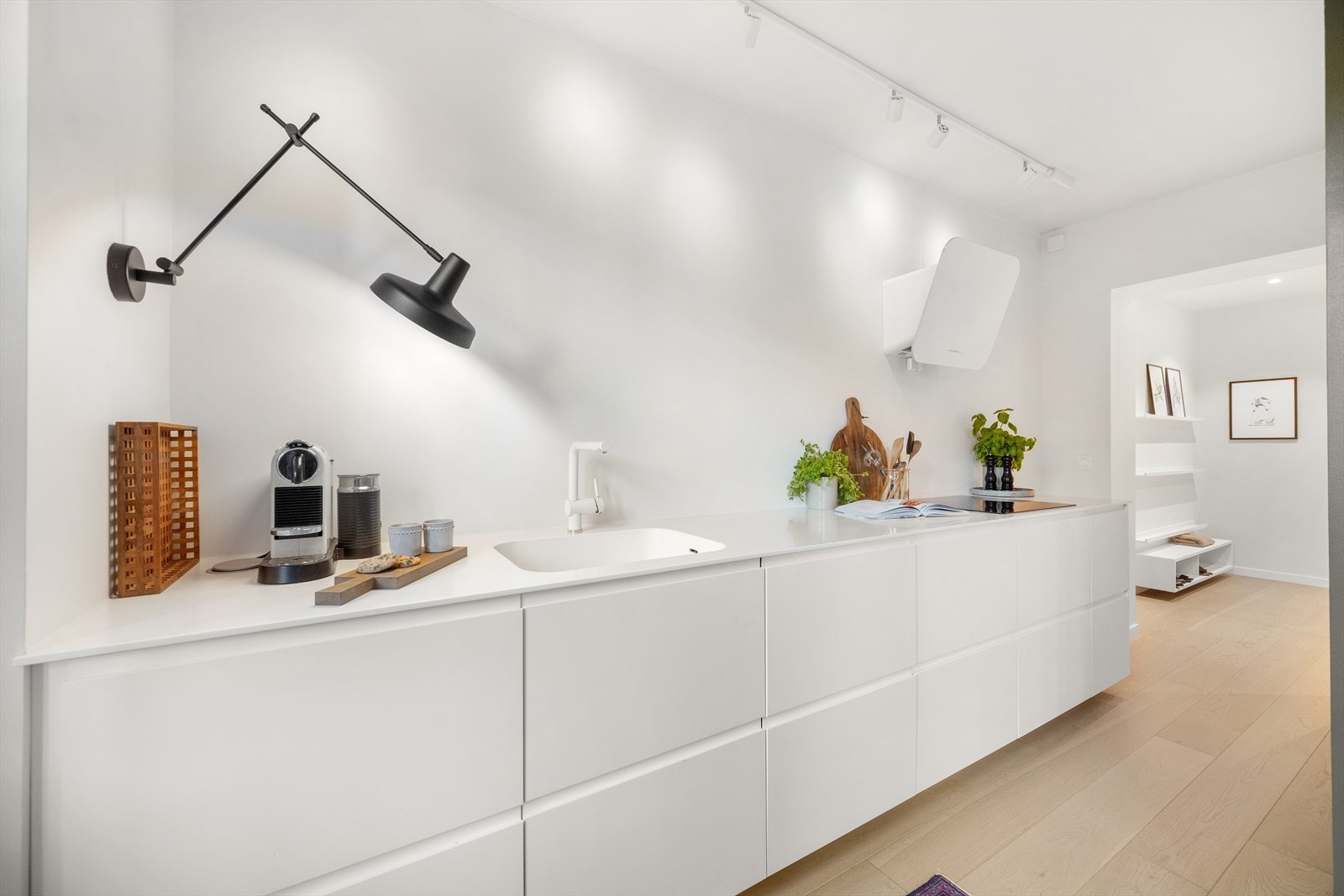 Eksklusiv benkeplate og vask i corian. Kjøkkenet er utstyrt med integrert platetopp, stekeovn, oppvaskmaskin samt kjøl- og fryseskap. Kullfilterventilator over kokeplass. Galleribilde