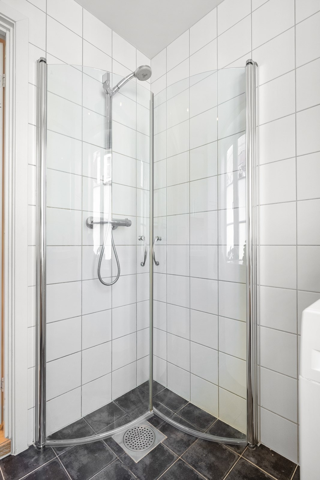 Badet er innredet med vegghengt klosett, servant nedfelt i innredning, speilskap med lys og dusjhjørne med svingbare glassdører. Galleribilde