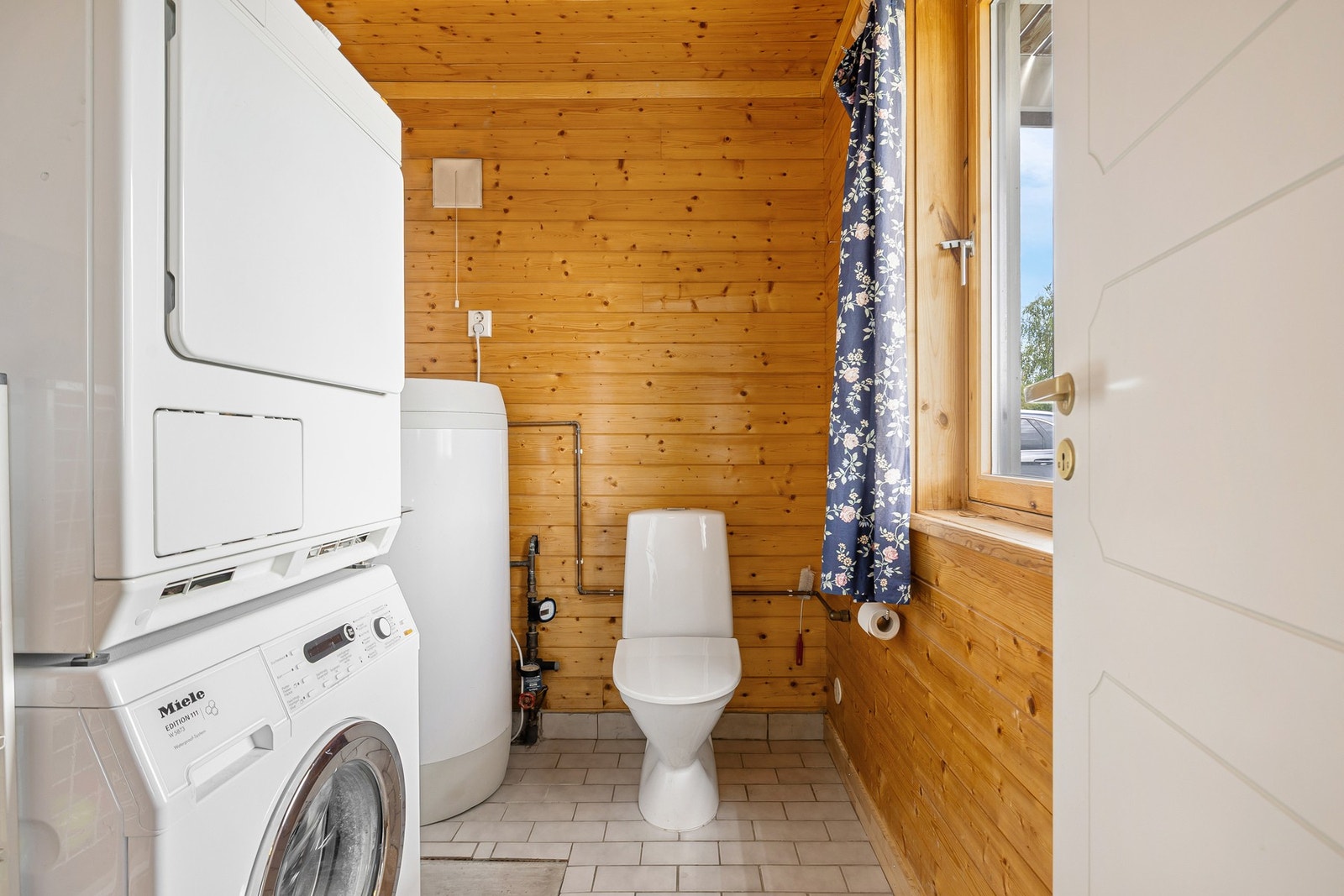 Praktisk vaskerom med opplegg for vaskemaskin. Galleribilde