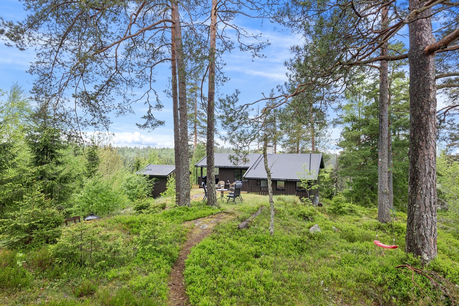 Eiendommen har en kupert naturtomt med trær og fjell i dagen. Galleribilde