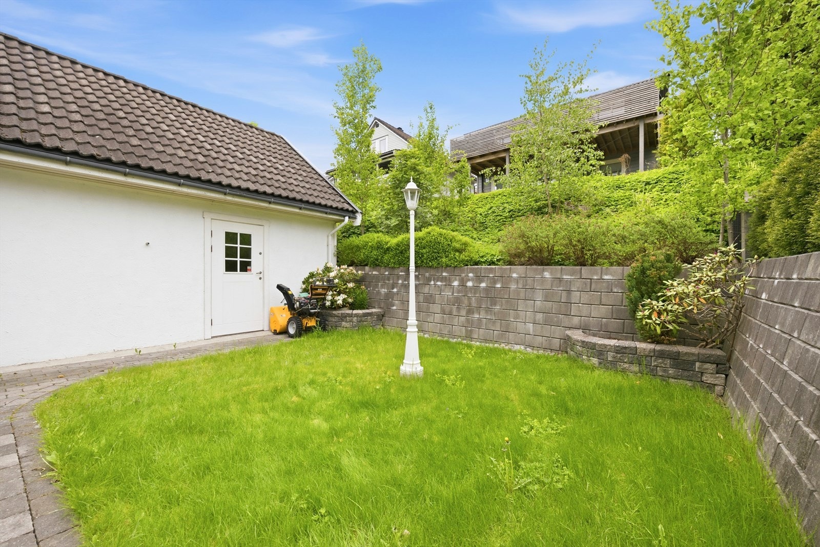 Pen og forseggjort tomt med variert beplantning og flere fine uteplasser hvor solen kan nytes gjennom dagen. Galleribilde