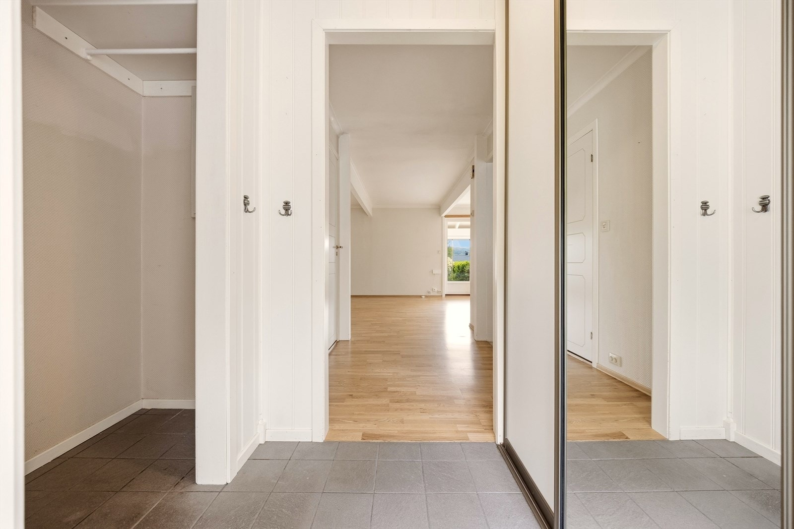 Flislagt entré med skyvedørsgarderobe og garderobenisje. Galleribilde