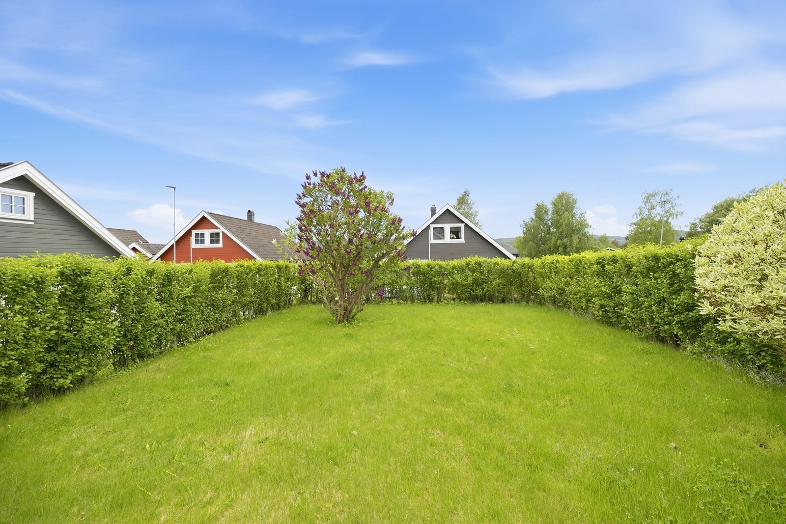 Hagen er omkranset av tett hekk. Her kan barna leke trygt og fritt. Galleribilde