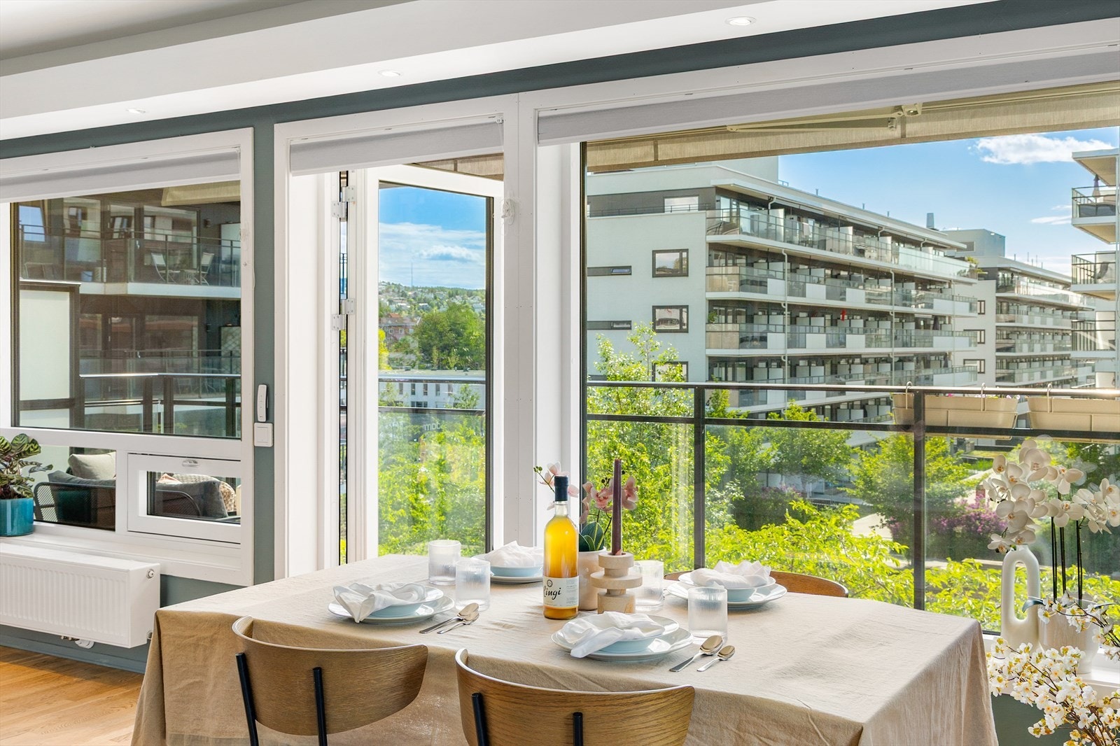 Store vindusflater og glassdør mot balkongen gir rikelig med dagslys i oppholdsrommet. Ønsker man å stenge igjen litt, så er vinduene utstyrt med plisségardiner Galleribilde