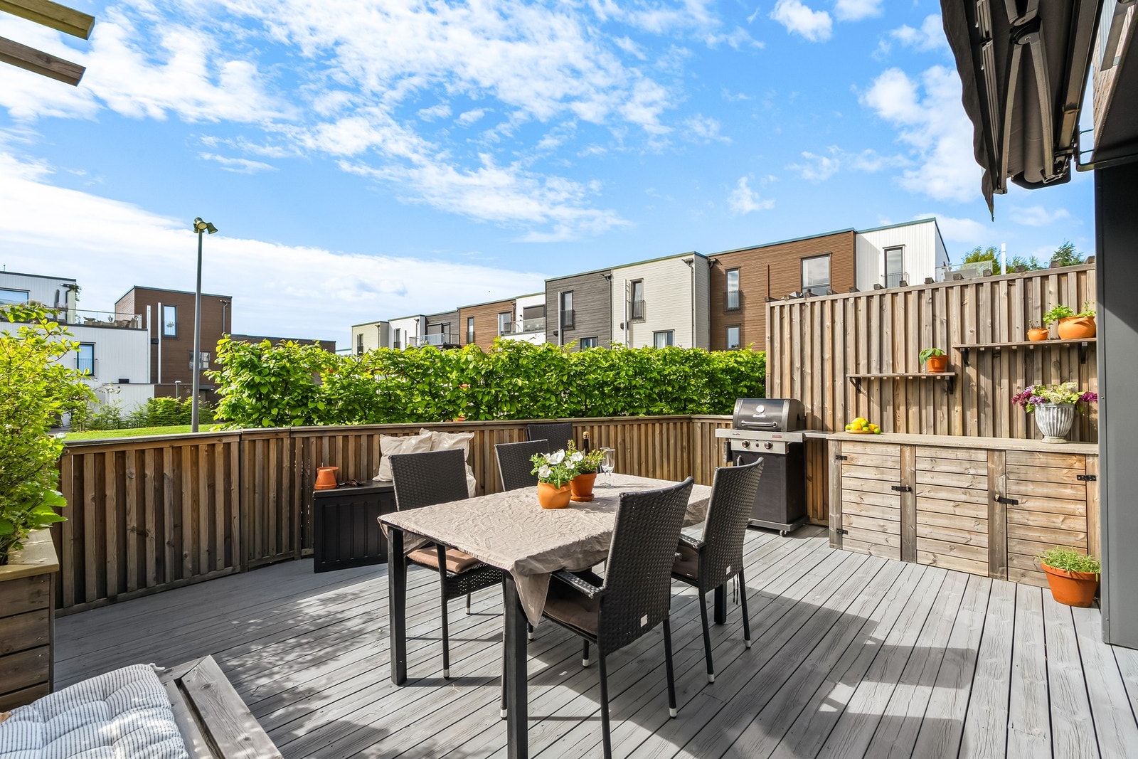 Terrassen er meget pent opparbeidet med terrassebord på gulv, samt rekkverk, levegger, innredninger og blomsterkasser i treverk. Galleribilde