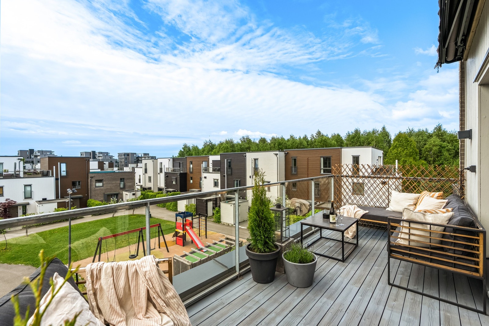 Terrassen har terrassebord på gulv, stilig rekkverk med glassfelt og god plass til sittegrupper. Galleribilde