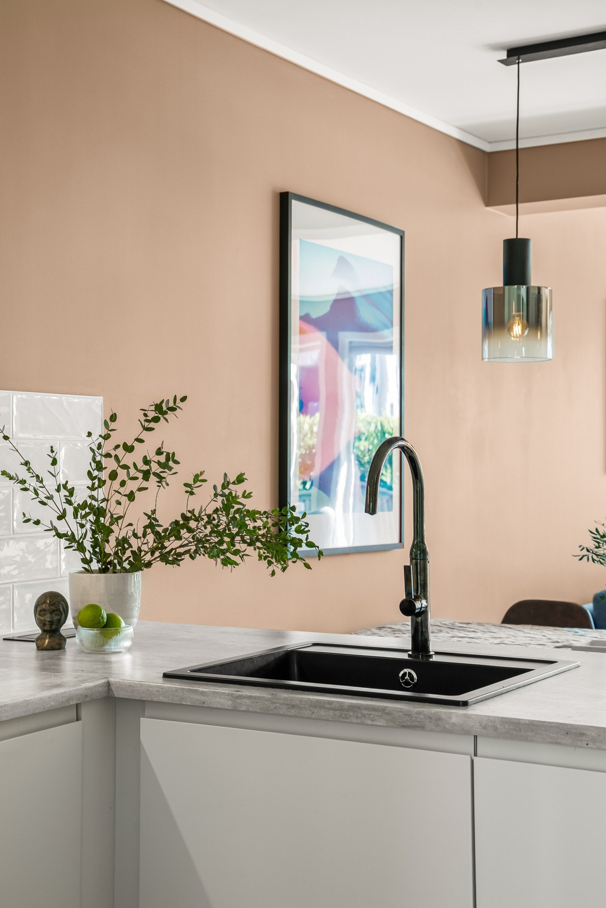 Innredningen har hvite glatte fronter og flott laminert benkeplate med nedfelt sort oppvaskkum med stilig armatur. Galleribilde