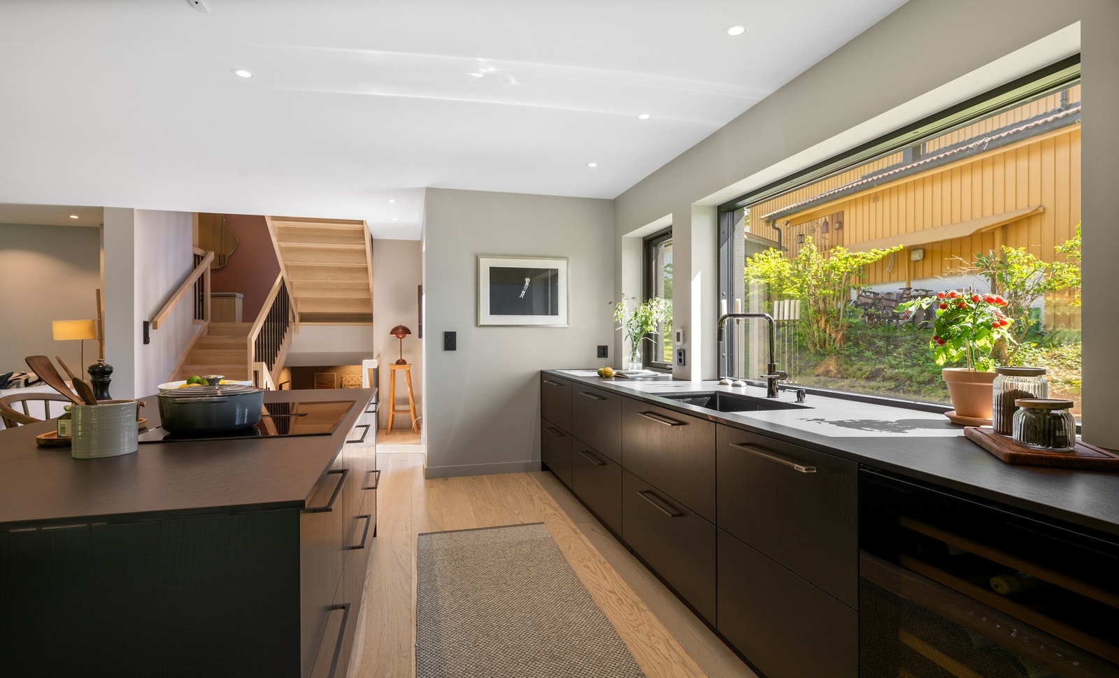 Kjøkkenet er møbelsnekret med Blum innredning, Sirius Dekton benkeplate, underlimt kum og store vindusflater som gir godt arbeidslys og en grønn utsikt. Galleribilde