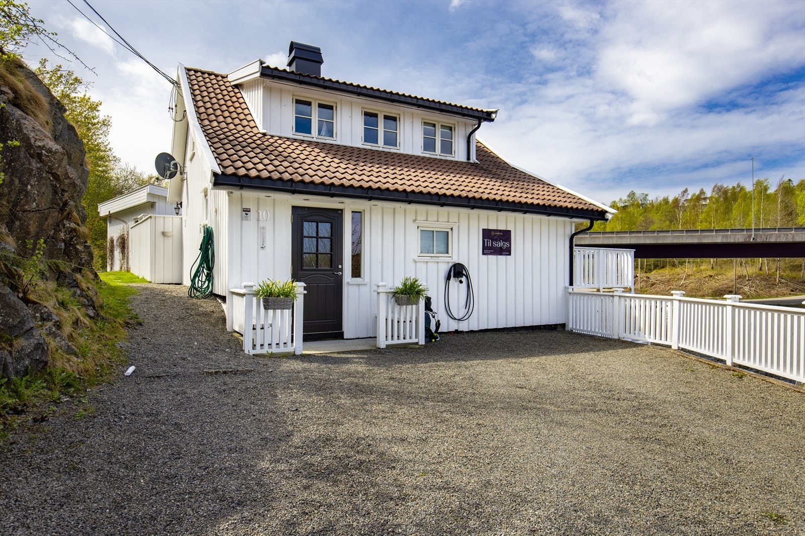 Utenfor er det biloppstillingsplass og montert elbil lader Galleribilde