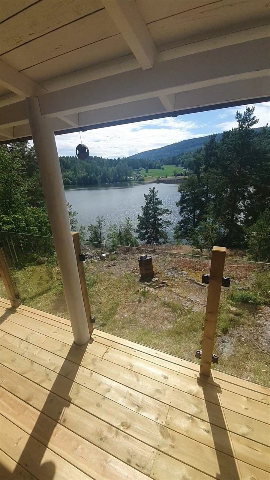 Flott utsikt fra terrassen og ned til vannet (selgers bilde) Bildene er tatt før/under bygging av verandaen, og før alle trærne var tatt ned. Galleribilde