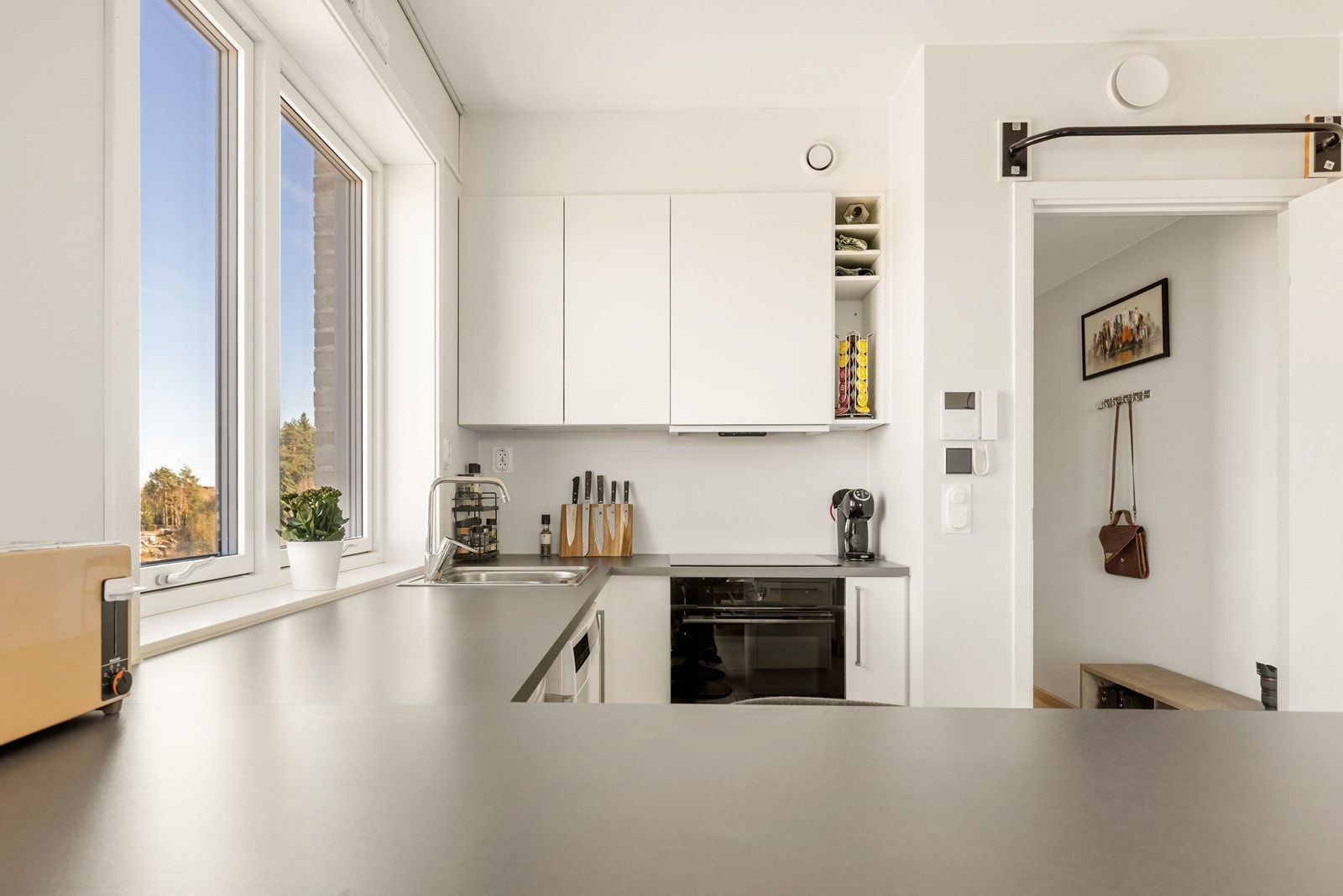 Kjøkkenet er levert av Sigdal og holder en moderne standard med hvite, glatte fronter og benkeplate i laminat. Galleribilde