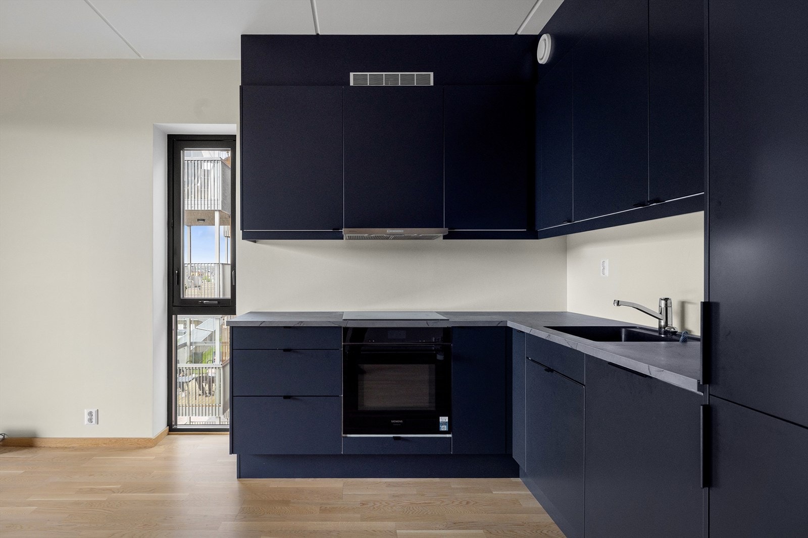 Kjøkkeninnredningen fra Sigdal er blågrå, ren og minimalistisk. De integrerte hvitevarene fra Siemens er utmerkede Galleribilde