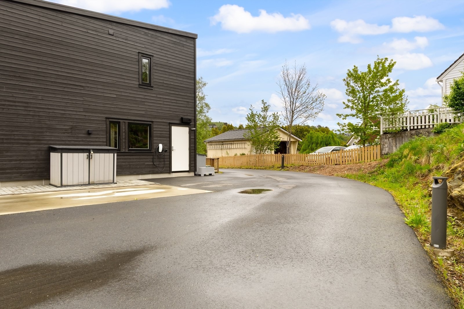 På baksiden av huset finner du parkeringsområdet med elbil-lader. Galleribilde