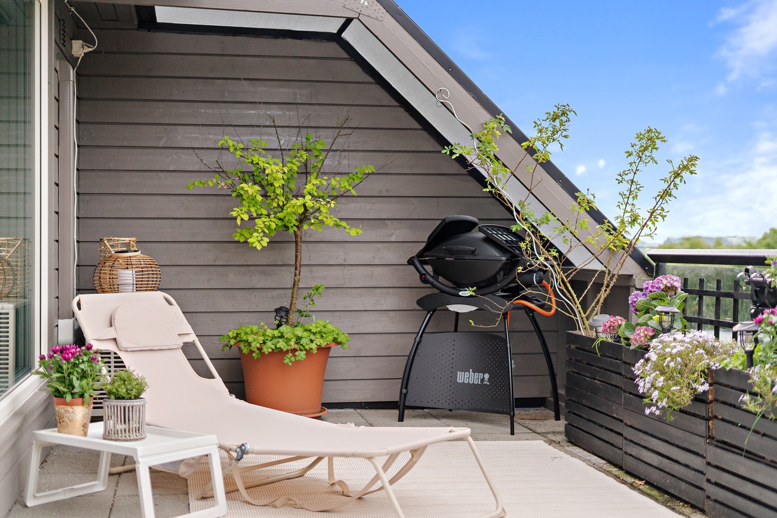 Solseng og grill plassert på terrassen - alt du trenger for en god sommer. Galleribilde