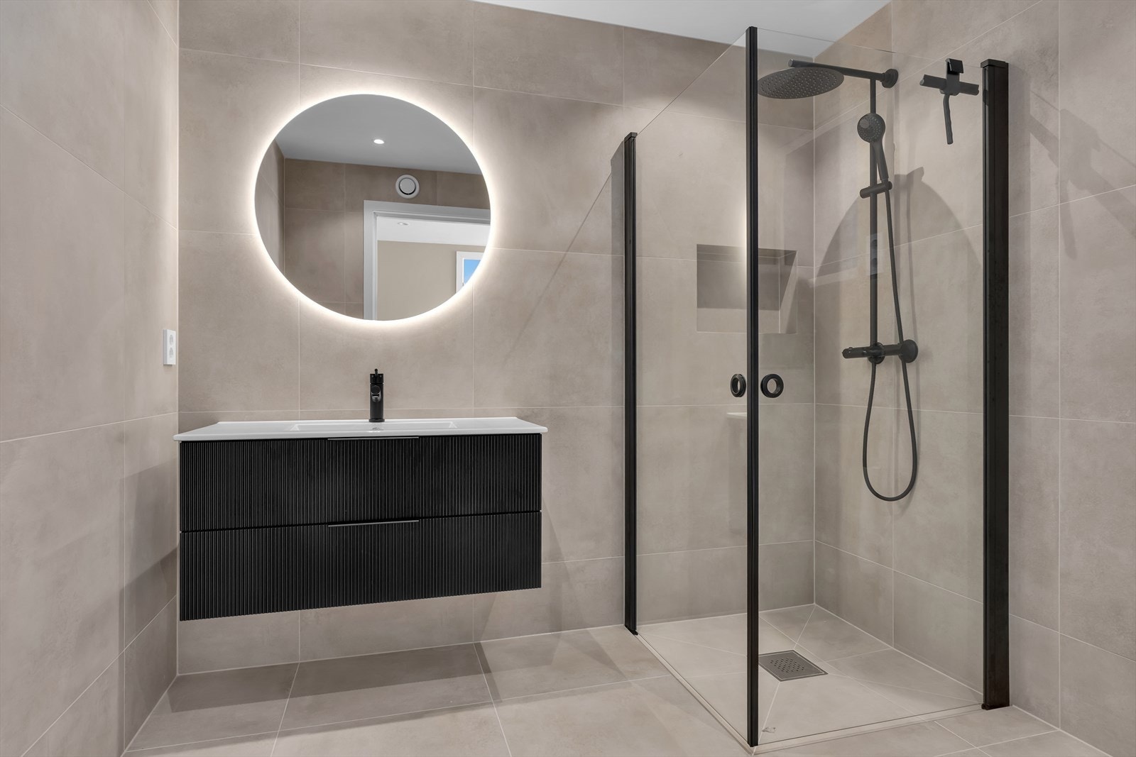 Sorte armaturer og detaljer gir en stilren kontrast på badet. (Illustrasjonsbilde fra tilsvarende bolig) Galleribilde