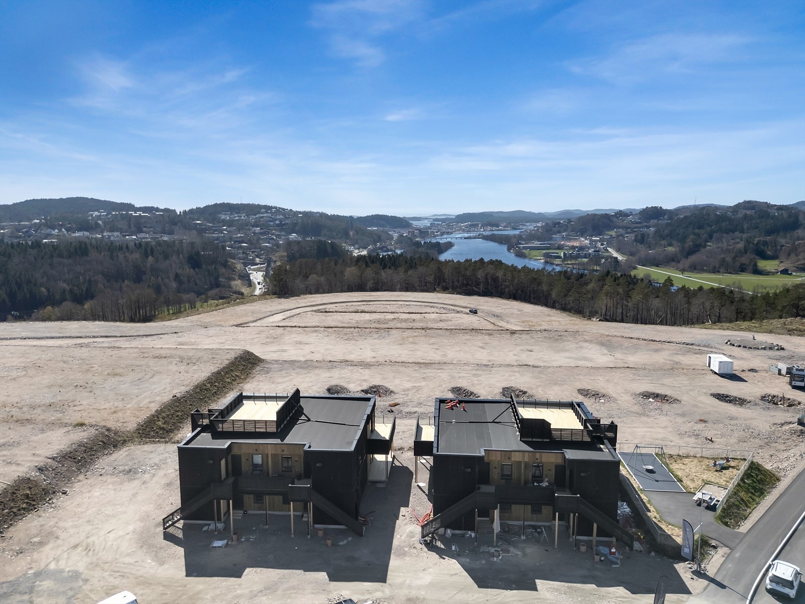 En oversikt som viser boligenes plassering i terrenget, med utsikt mot Mandal by og sjøen. Galleribilde