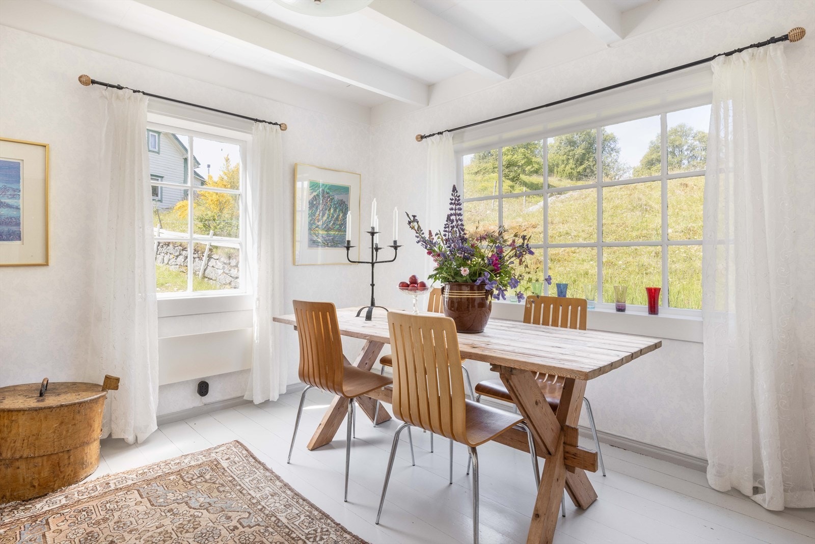 Store vindusflater med sprosser slipper inn rikelig med dagslys og gir en vakker innramming av tunet utenfor. Galleribilde