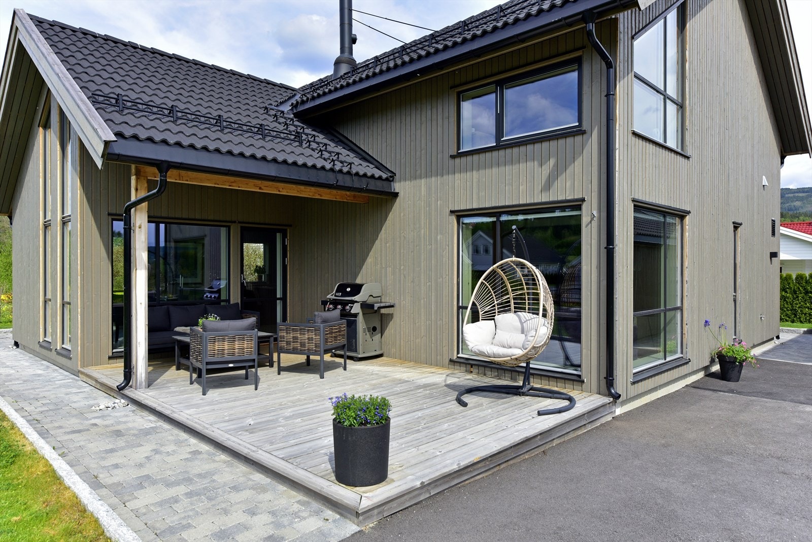 Tomten er opparbeidet med plen, og gårdsplassen er asfaltert. Galleribilde