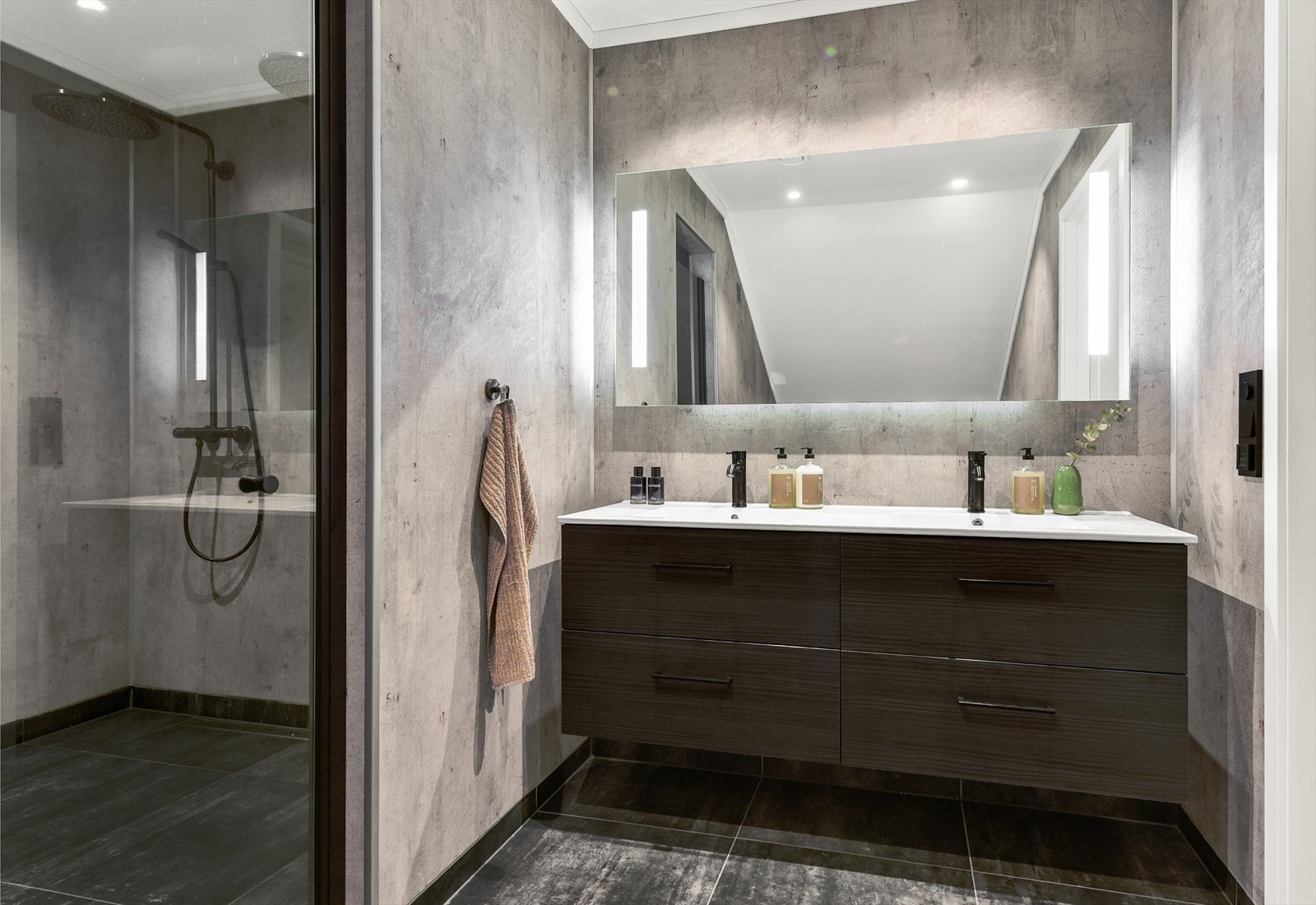 Badet i loftsetasjen har flislagt gulv med gulvvarme og dobbelservant. Galleribilde