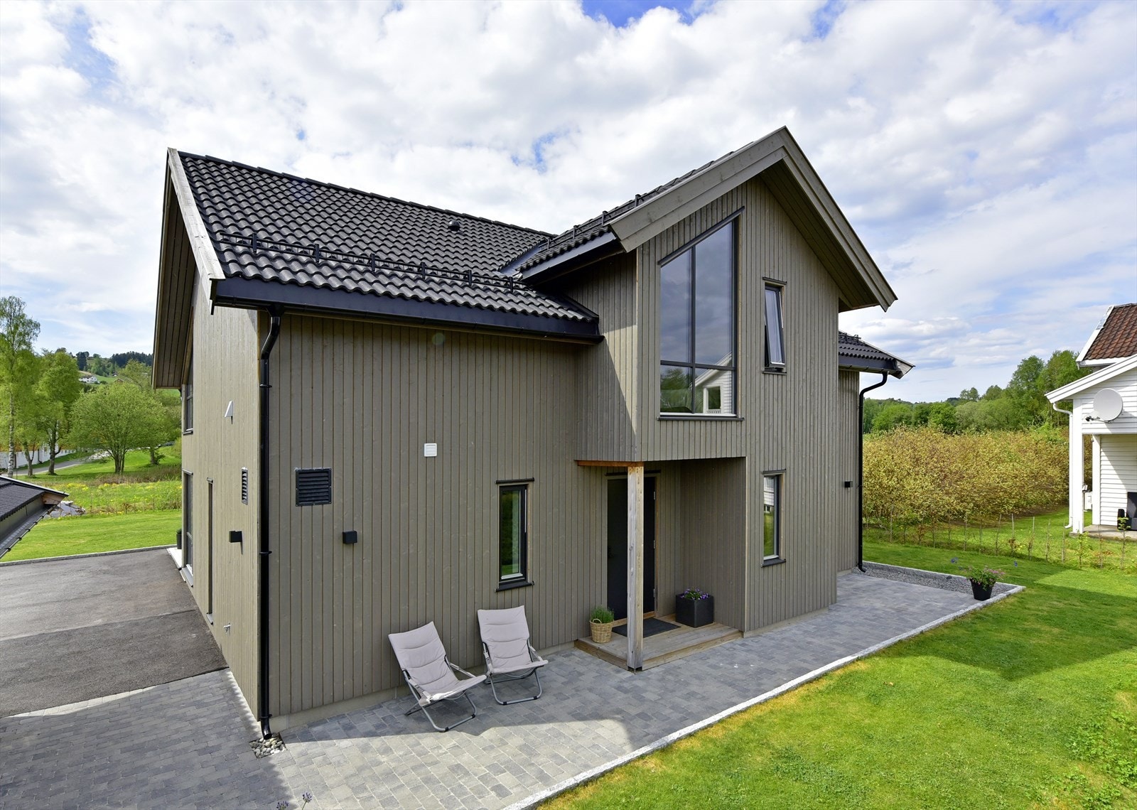 Stående utvendig trekledning og tak tekket med betongtakstein. Galleribilde