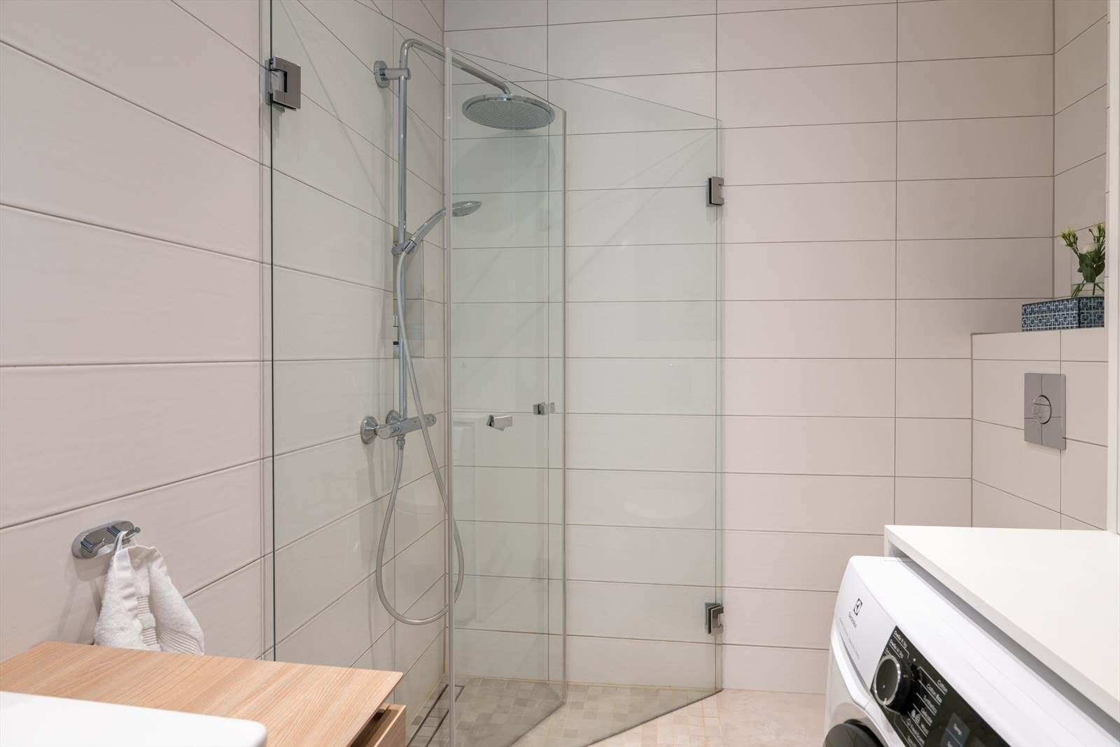 Badet er innredet med vegghengt wc, dusj med innfellbare glassdører og praktisk nisje med plass til sjampo og såpe, samt servantskap med armatur fra Tapwell. Galleribilde