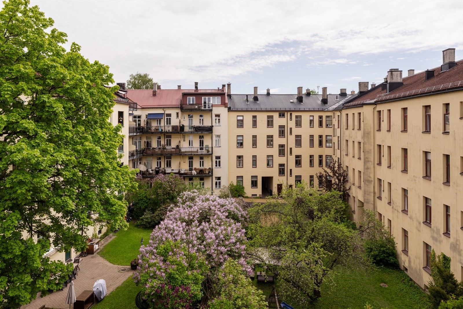 Nydelig utsyn over frodig og parkmessig bakgård med syrintrær, grønne plenarealer og klassiske bygårder. Her bor man stille og tilbaketrukket, med en sjelden følelse av luft og rom midt i byen. Galleribilde
