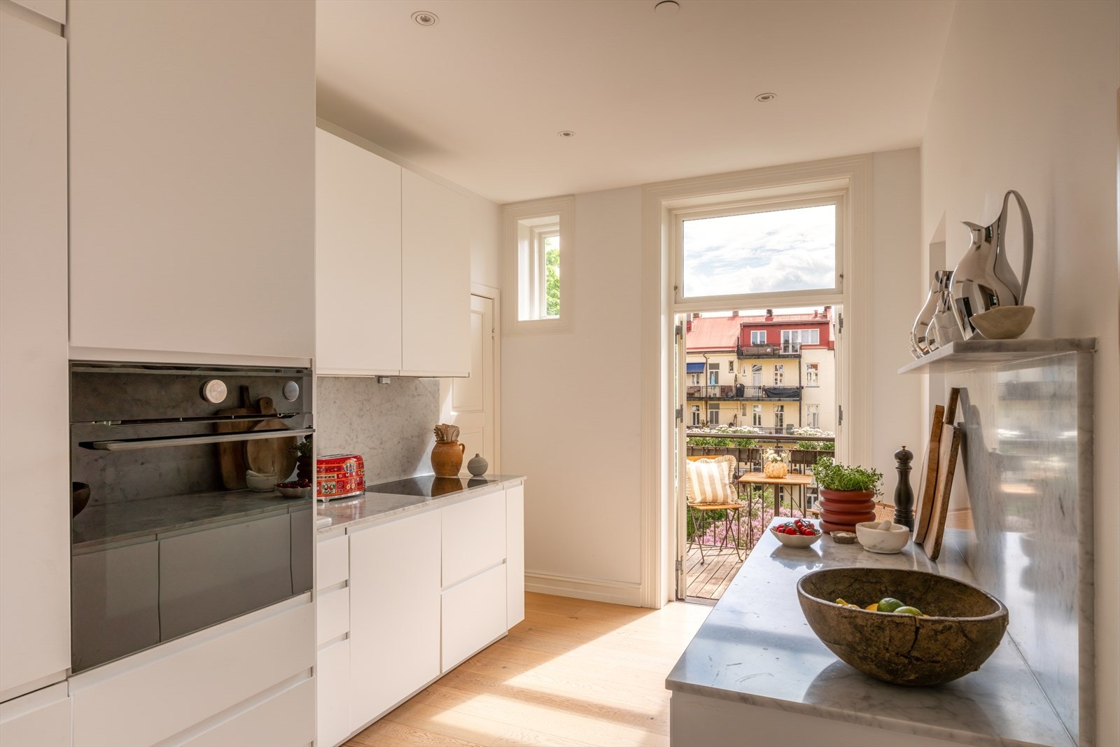 Et pent og moderne kjøkken med stilrent uttrykk og gode arbeidsflater. Kjøkkeninnredningen fra 2019 har glatte fronter og eksklusiv Carrara-benkeplate med backsplash i samme utførelse, som gir et helhetlig og elegant preg. Galleribilde