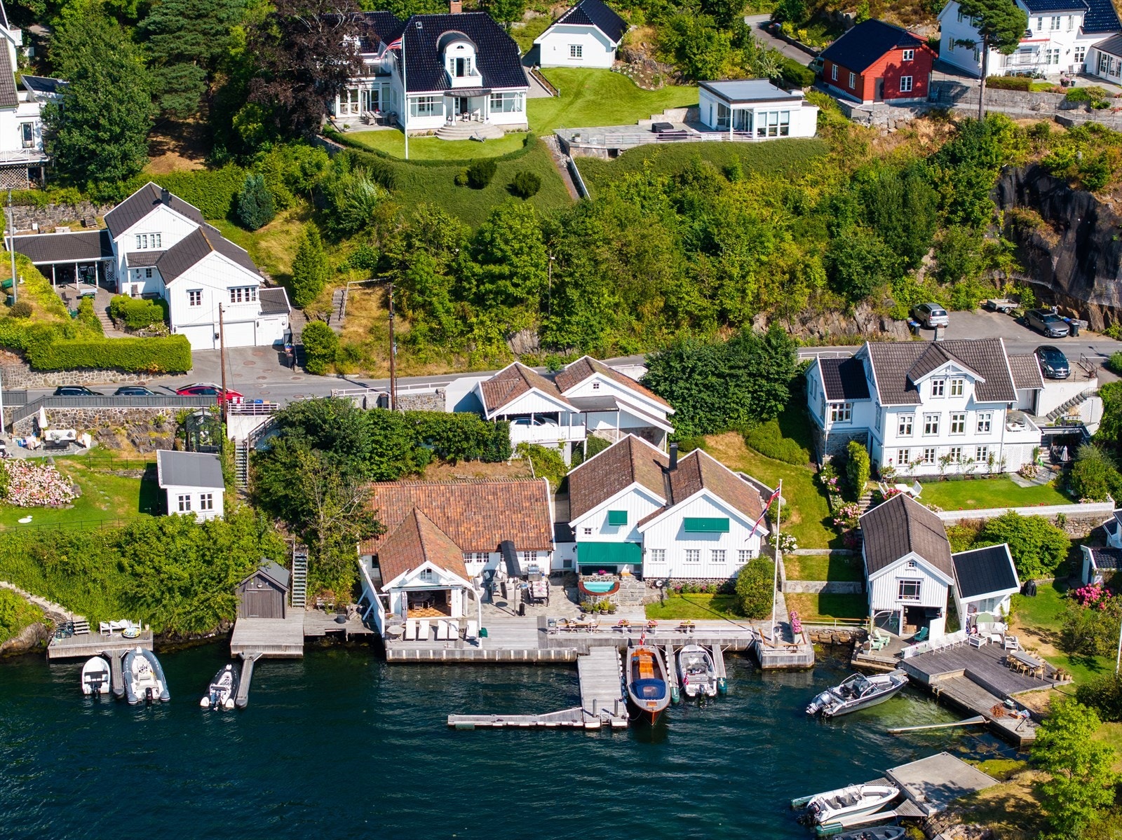 Forøvrig er det flott opparbeidelse med plen, murer og bed over flere nivåer, trapper og murer, skiferterrasse, skjermet spiseplass med markiser, nedfelt jacuzzi og flere terrasser og lune uteplasser. Galleribilde