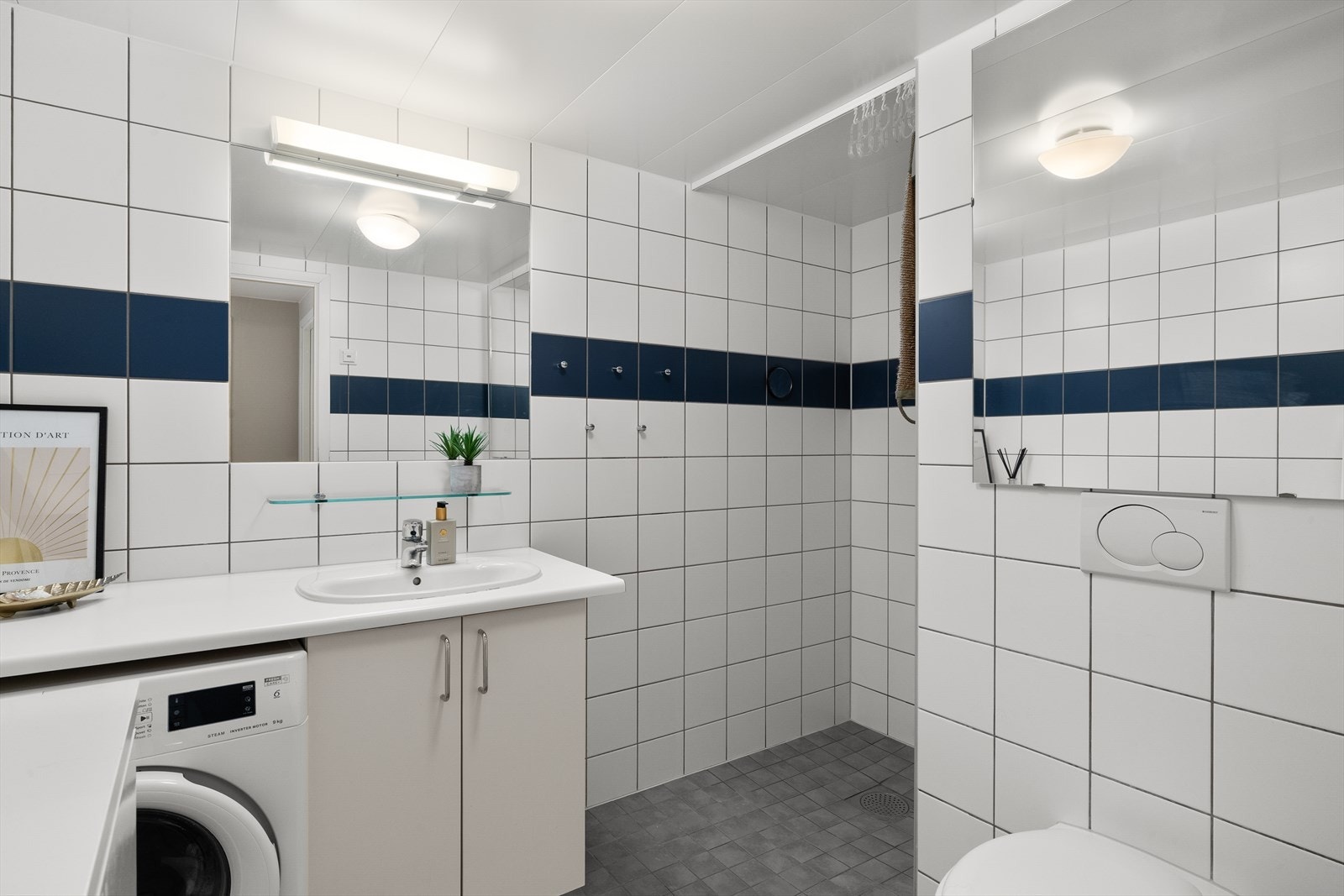 Badet er helfliset og utstyrt med varmekabler, dusjhjørne, wc, servant samt opplegg for vaskemaskin. Galleribilde