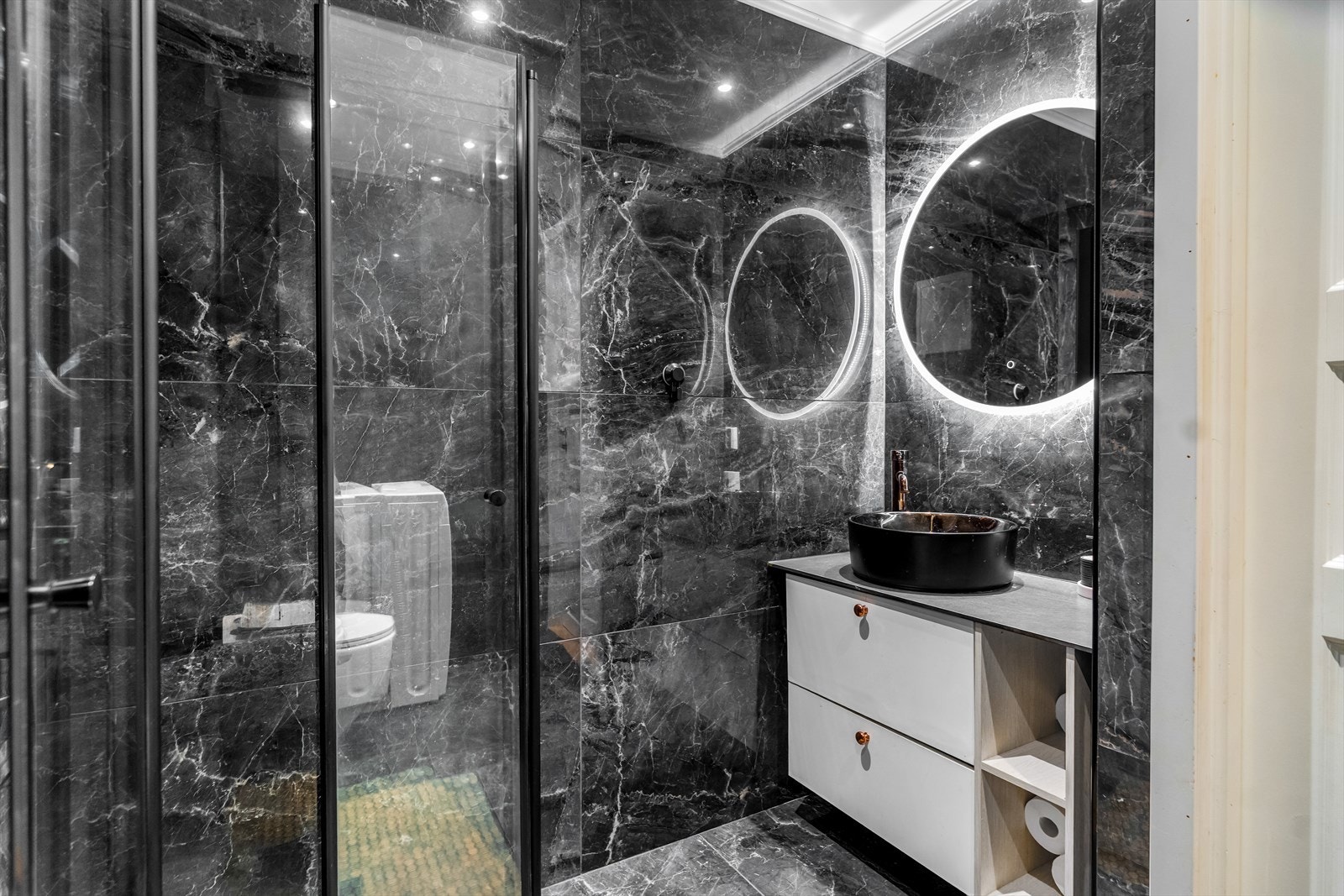 Badet har store fliser på vegger og gulv, samt varmekabler. Galleribilde
