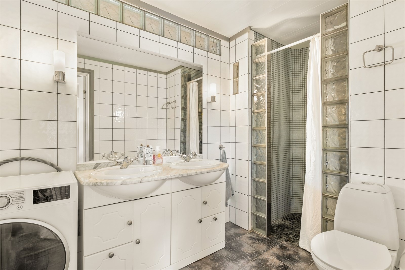 Badet i første etasje er fra byggeåret, med fliser på gulv og vegger. Galleribilde