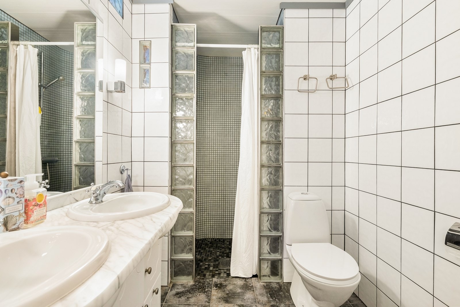 Badet er innredet med dobbel servant, toalett, dusjnisje og har opplegg for vaskemaskin. Galleribilde