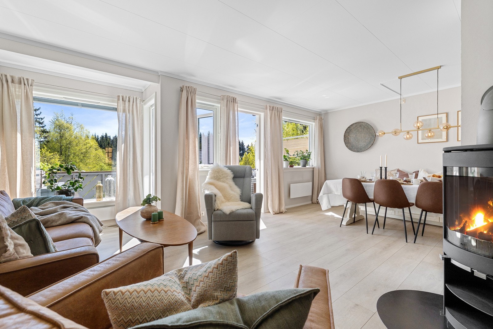 Lys stue med store vindusflater som slipper inn mye naturlig lys i boligen. Galleribilde