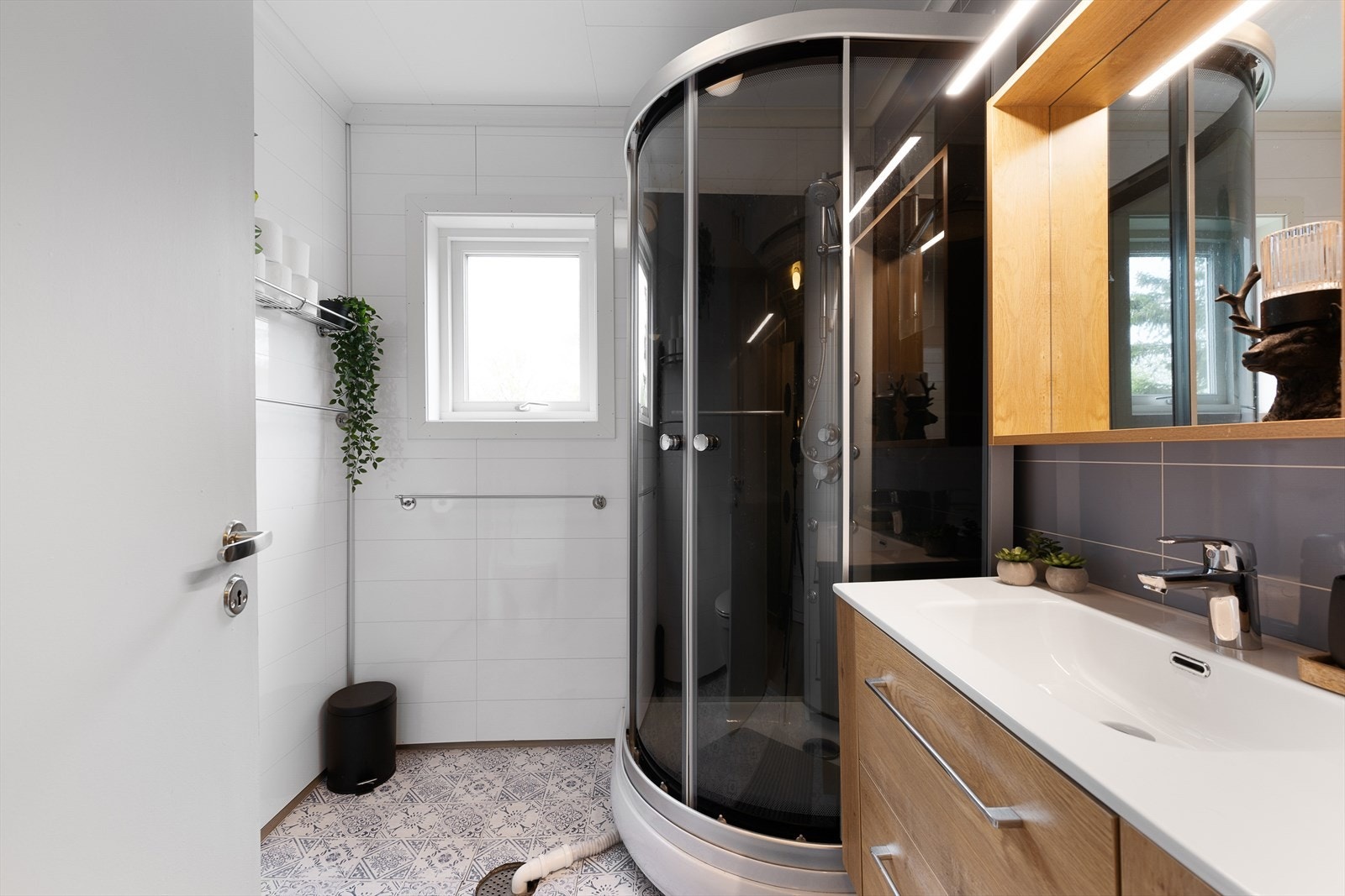 Badet i første etasje har vinylbelegg, dusjkabinett og baderomsplater på veggene. Galleribilde